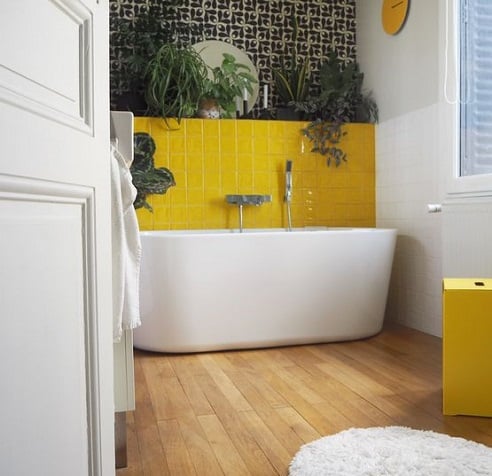 Salle de bain jaune avec baignoire ilot